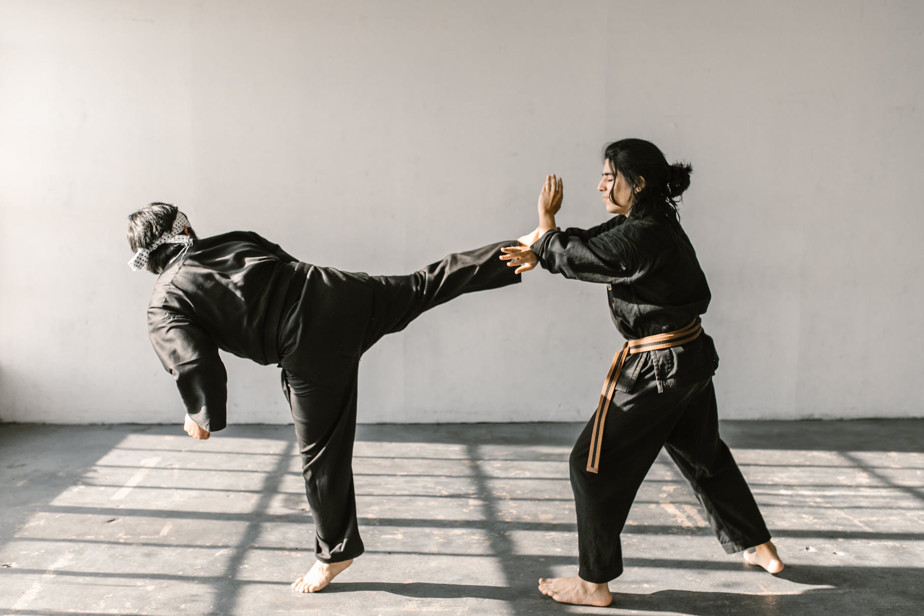 long haired man defending himself from the person s kick